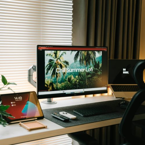 Stylish home office with dual monitors, tablet, and modern design elements.